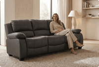 Woman sitting on a gray sofa in a well-lit living room.