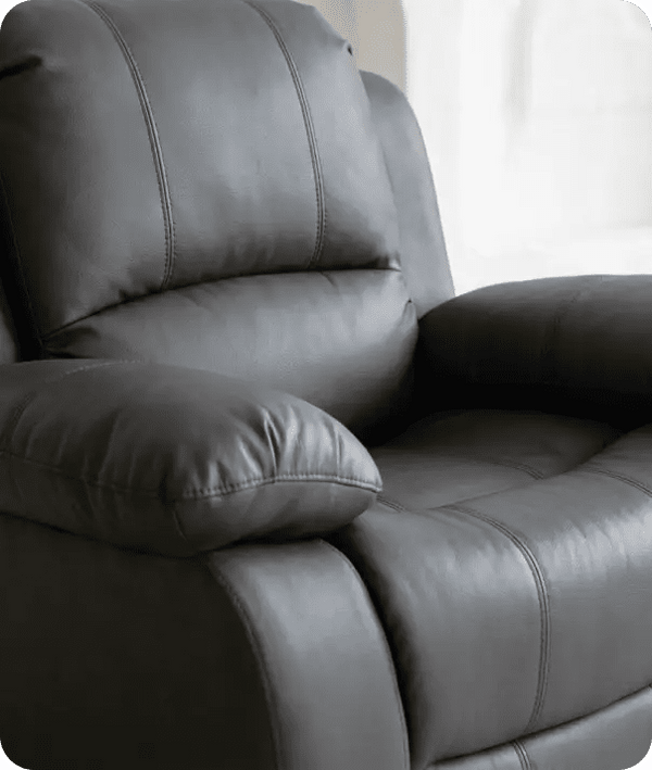 Gray leather recliner chair in a room with white walls.