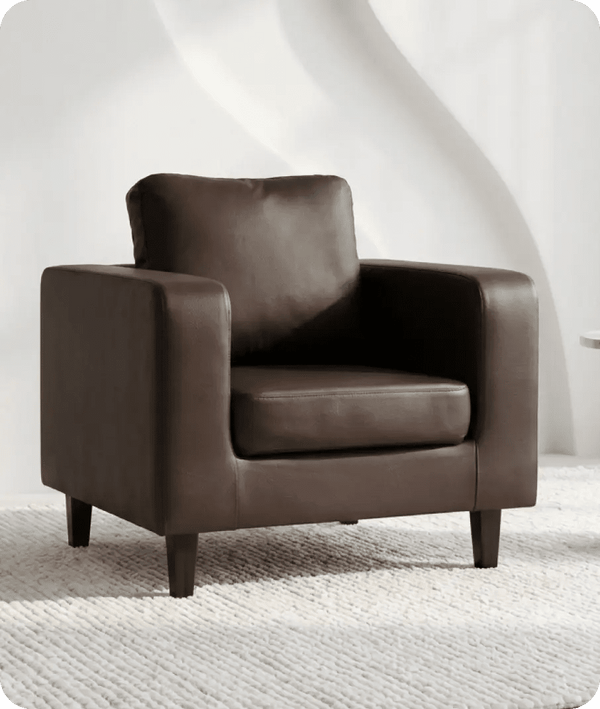 Brown leather armchair on a textured white floor with a white wall background