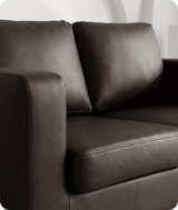 Brown leather sofa with a white curtain in the background