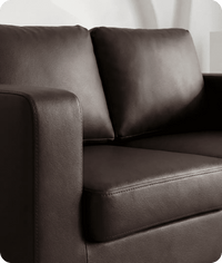 Brown leather sofa with a white curtain in the background