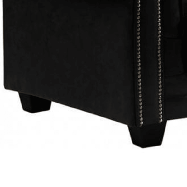 Black upholstered chair with nailhead trim on a white background