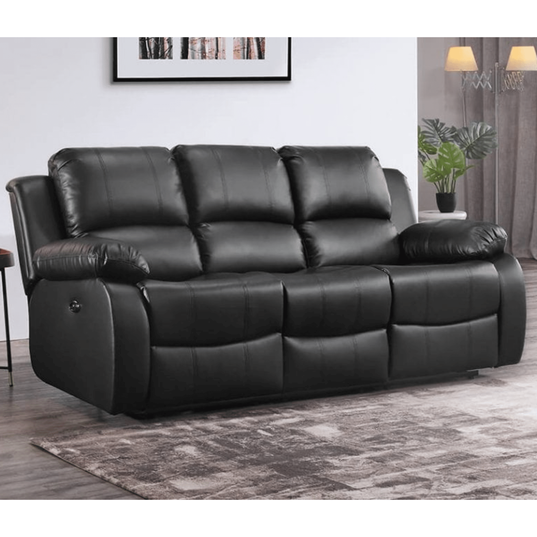 Black leather sofa in a living room setting with a rug and wall art.